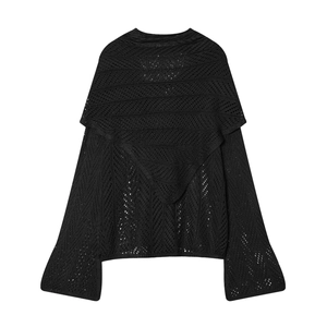 Detailed close-up of black knitted hollow long sleeve shawl with fine crochet texture