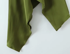 Detailed close-up of smooth olive green satin fabric with asymmetric hem and draping folds