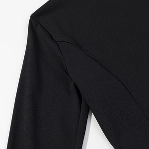 Close-up of black shirt shoulder seam showing high-quality stitching and fabric texture