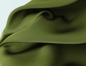 Detailed close-up of olive green dress fabric showing soft texture and premium matte finish