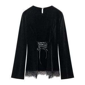 Detailed back view of black velvet top featuring lace-up ribbon and floral lace hem