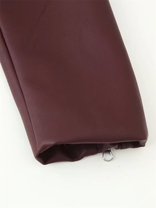 Détail de la manche d'une veste en similicuir bordeaux avec une fermeture éclair en métal