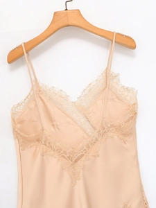 Detail of champagne satin camisole featuring delicate eyelash lace trim and thin straps