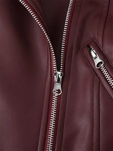 Détail de la veste en cuir bordeaux montrant la texture fine et les fermetures éclair en argent