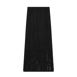 Detail of black knit maxi skirt featuring a delicate hollow-out wave pattern and high waist
