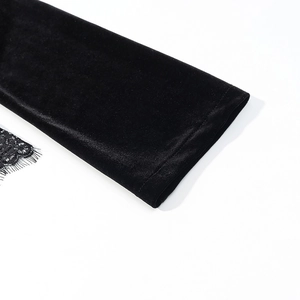 Detailed macro view of black velvet sleeve with delicate floral eyelash lace trim