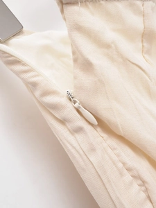 Detail of invisible zipper and beige cotton linen fabric texture on midi skirt