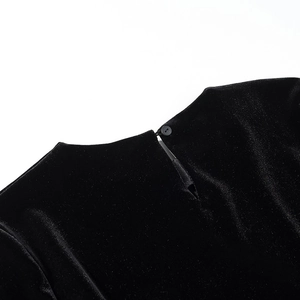 Close-up of black velvet top neckline featuring round button and teardrop cutout detail