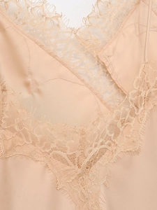 Detailed macro view of champagne satin camisole with delicate eyelash lace trim