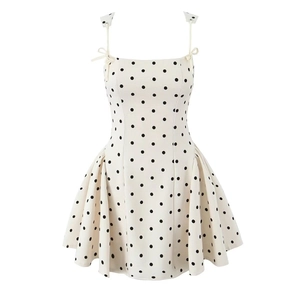 Detailed view of white polka dot dress with bow shoulder straps and ruffled skirt