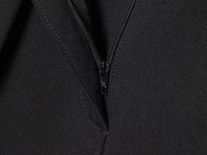 Vue macro de la fermeture éclair métallique noire sur un pantalon en tissu tissé