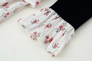 Detail of velvet dress sleeve with floral chiffon ruffle cuff and delicate textures