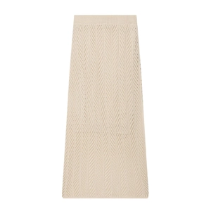Detailed close-up of the beige hollow knit texture and ribbed waistband of the midi skirt