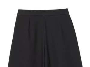 Détail de pantalon noir taille haute avec plis symétriques et tissu tissé affiné