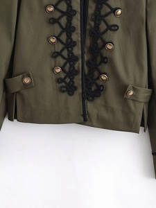 Detail of dark green military style jacket featuring intricate black frogging and brass buttons