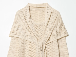 Detail of cream knit two-piece set with hollow geometric pattern and front tie