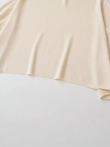 Close-up of soft beige knit top showing fine ribbed texture and premium stitching