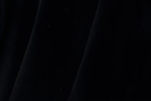 Close-up of the black velvet fabric texture showing soft plush surface and fine details