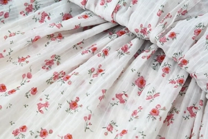 Detail of floral chiffon fabric with vertical texture and soft pink flower patterns