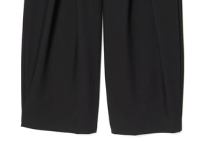 Vue détaillée du pantalon noir à jambes larges montrant l'ourlet net et le tissu fluide