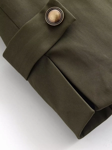 Detailed macro view of olive green twill fabric and vintage bronze metal button