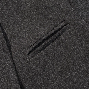 Detailed macro view of black blazer fabric featuring double welt pocket and fine stitching