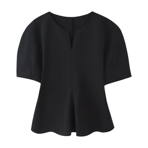 Detail of the V-neckline and structured peplum hem on this black short sleeve top