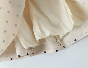 Detailed macro view of beige polka dot dress hem with clean stitching and inner lining