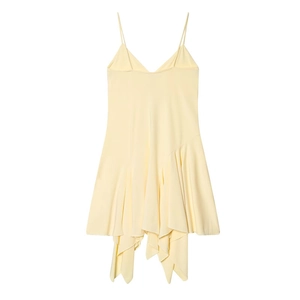 Detail of cream yellow slip dress featuring asymmetric ruffled hem and deep V-neckline