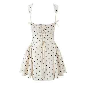 Detail of white polka dot dress featuring a criss-cross lace-up back design