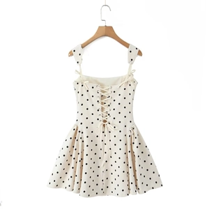 Detailed back view of white polka dot dress featuring lace-up metal eyelets