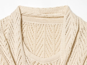 Close-up of beige crochet knit shawl showing hollow knit texture and layered collar detail