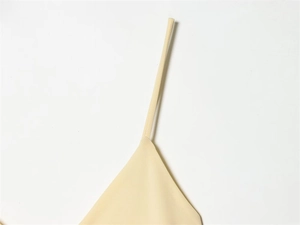 Detail shot of fine stitching on the spaghetti strap of a beige summer dress