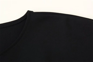 Detailed close-up of double-stitched neckline and fabric texture on a black crewneck top
