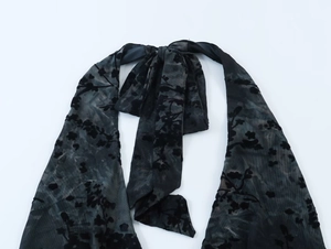 Détail de la cravate en maille floquée noire avec motifs floraux et velours