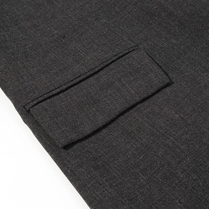 Detail of charcoal grey blazer featuring a neat flap pocket and fine twill fabric texture