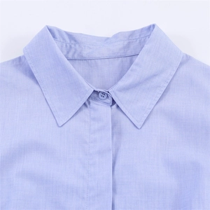 Close-up of a light blue button-down shirt collar with premium fabric texture
