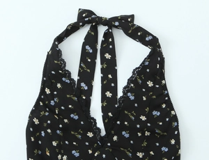 Détail de robe fleurie avec décolleté en V, bordure en dentelle et nœud papillon au cou