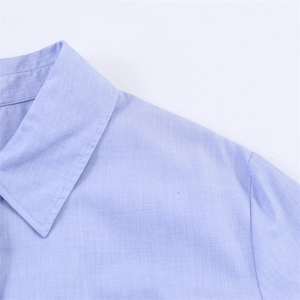 Close-up of the turn-down collar and woven fabric texture of a light purple shirt