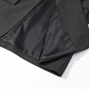 Detailed macro view of gray blazer interior showing smooth black satin lining and fine stitching