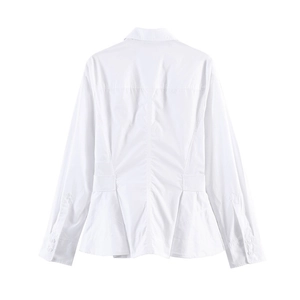 Detail view of the structured peplum hem and back seam design on a white cotton shirt
