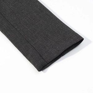 Detailed macro view of dark grey worsted fabric texture and sleeve stitching on jacket