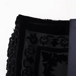 Elegant black velvet mini skirt with intricate floral flocking and decorative fringe trim