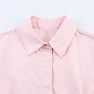 Close-up of a light pink shirt collar with neat stitching and small matching buttons