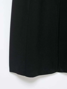 Gros plan de l'ourlet du manteau noir en laine avec coutures et texture de tissu qualité