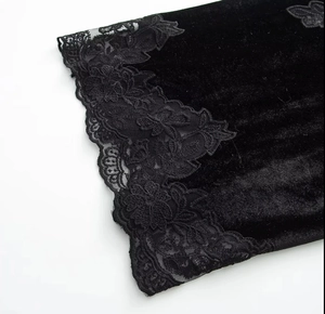Detail of elegant black velvet dress showing intricate lace patchwork on the sleeve cuff