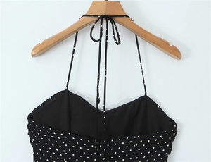 Dettaglio dell'abito nero a pois con scollo all'americana e bordo in pizzo bianco fine