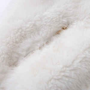 Close-up of fluffy white faux fur fabric with a premium golden metal zipper detail