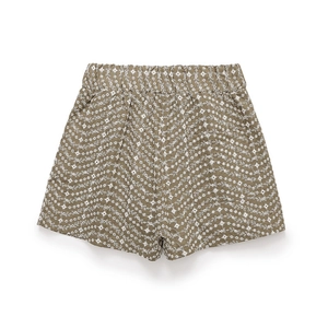 Détail du short vert olive avec broderie florale blanche et textures ondulées festonnées