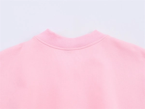 Detail of soft pink ribbed crewneck collar on a casual bomber jacket with clean stitching